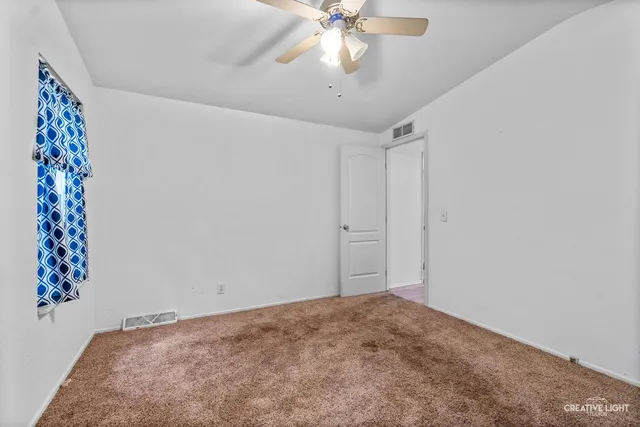 en empty room with window and ceiling fan
