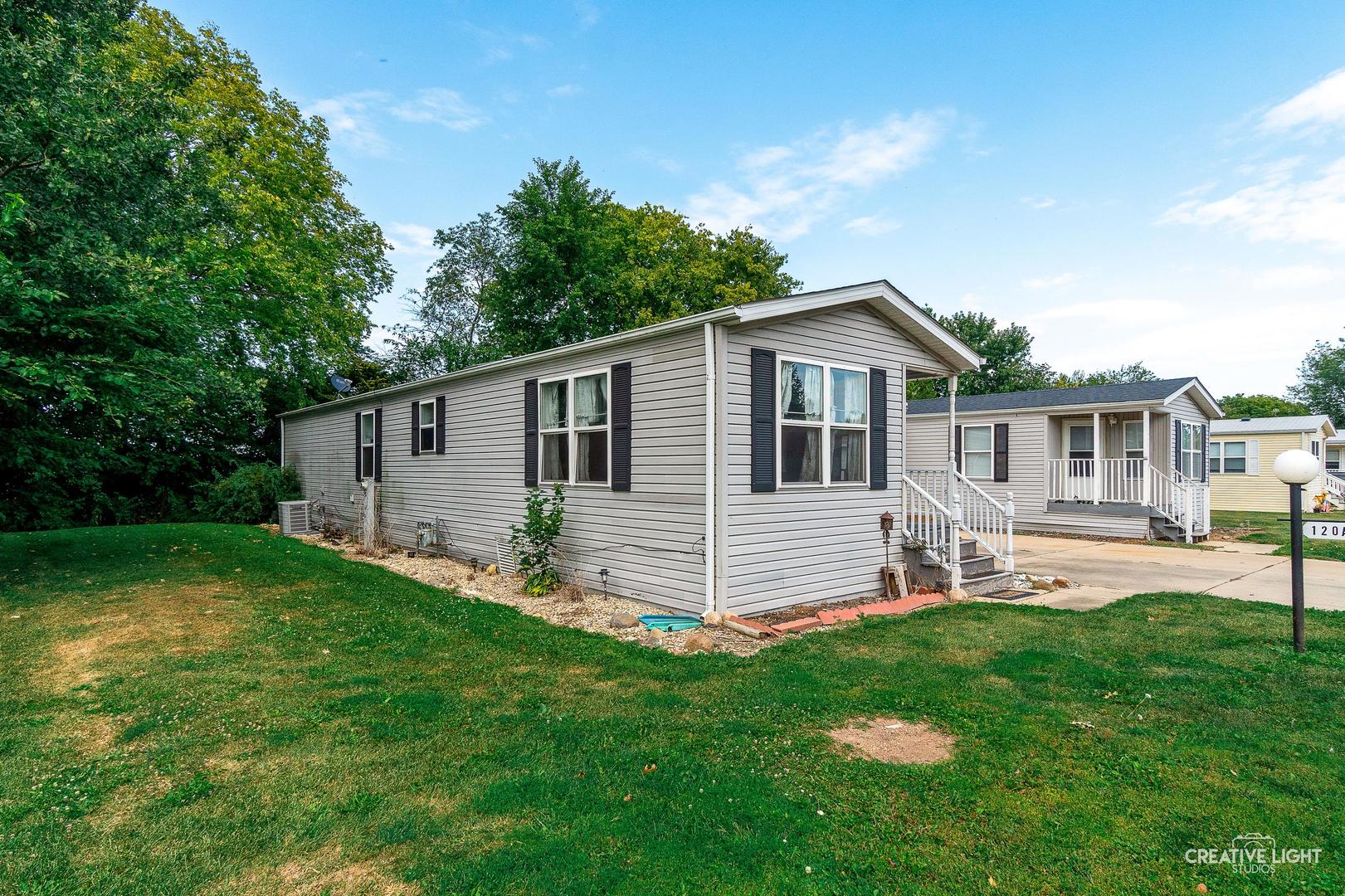 120 Cardinal Lane, Unit A Sandwich, IL 60548 - Photo 3 of 15 a front view of house with a garden and patio