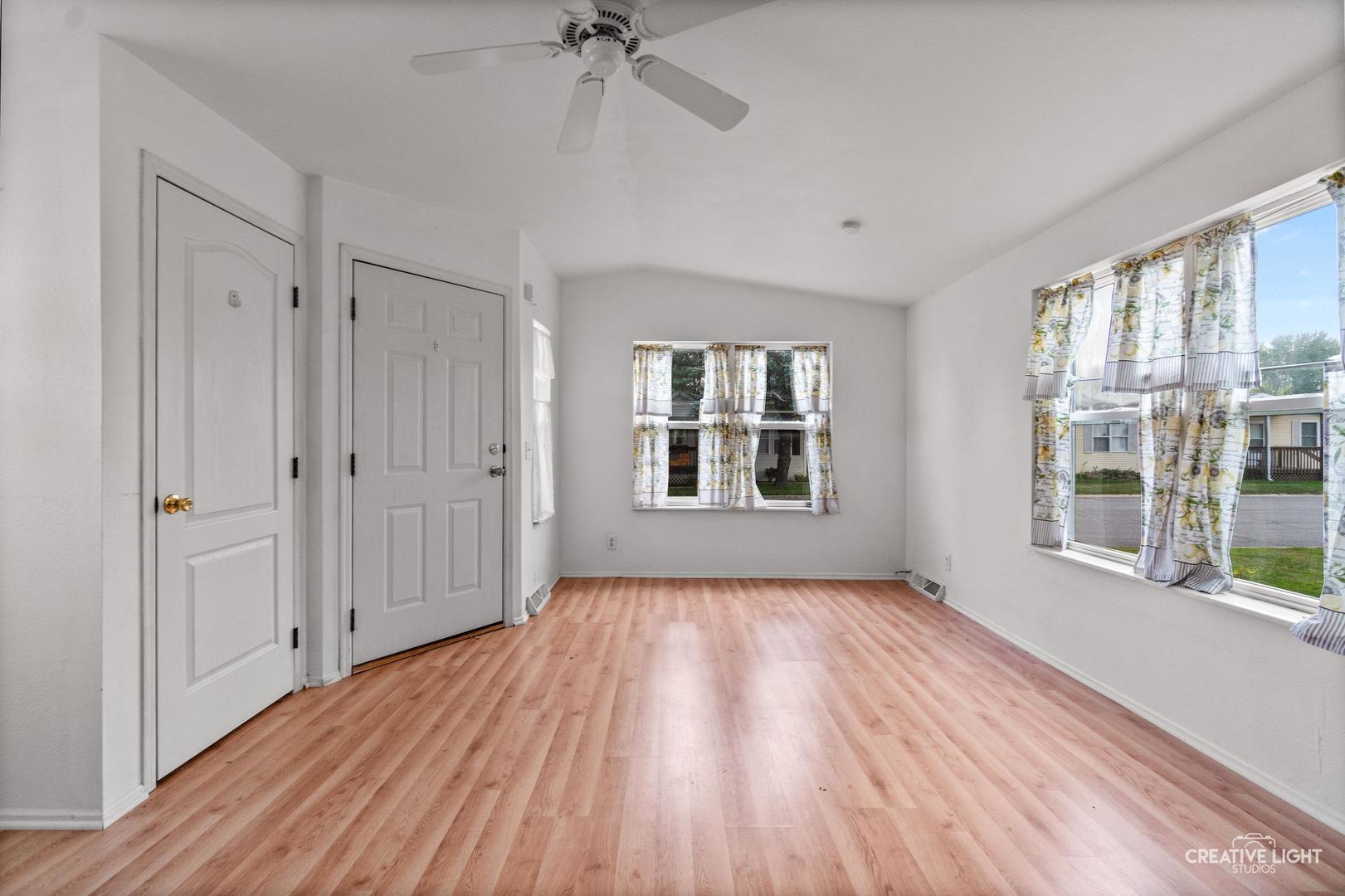 120 Cardinal Lane, Unit A Sandwich, IL 60548 - Photo 5 of 15 a view of an empty room with a window and wooden floor