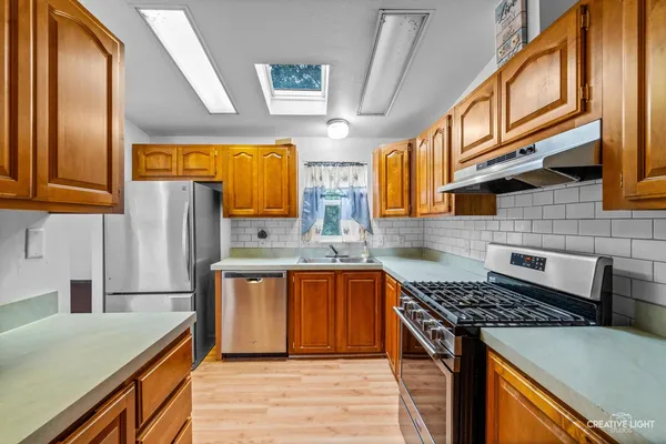 a kitchen with stainless steel appliances granite countertop a stove and a refrigerator