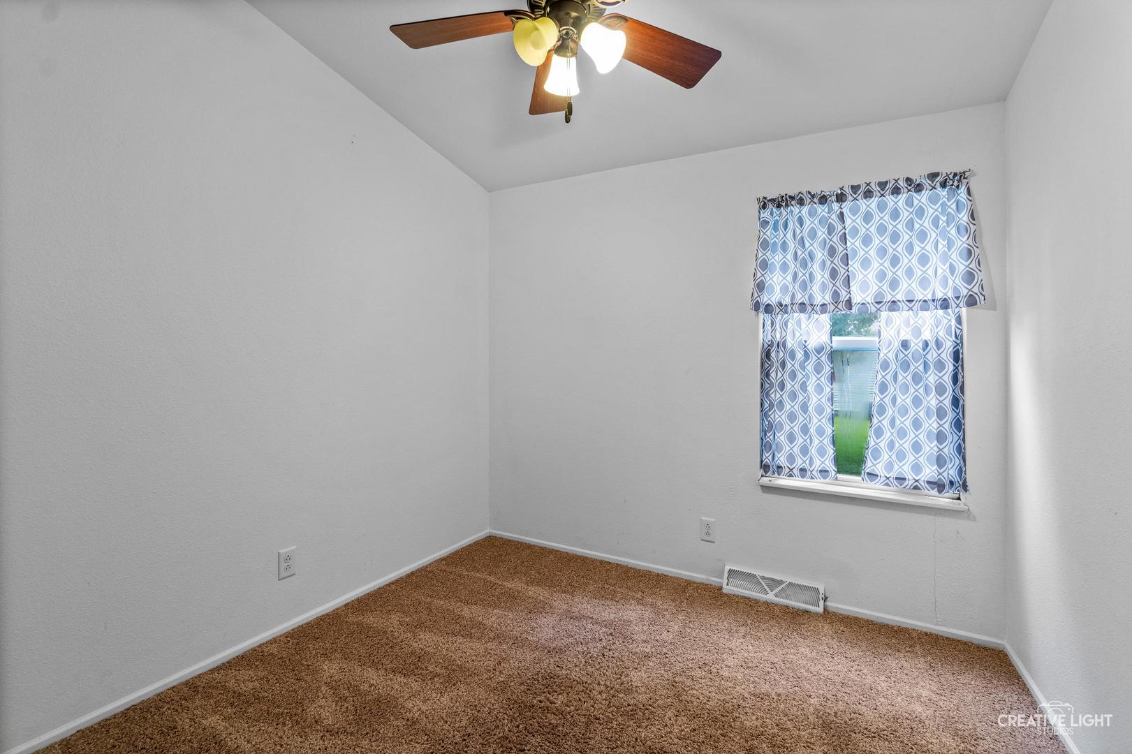 120 Cardinal Lane, Unit A Sandwich, IL 60548 - Photo 8 of 15 an empty room with window and ceiling fan
