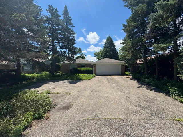 a front view of a house with a yard and a garden
