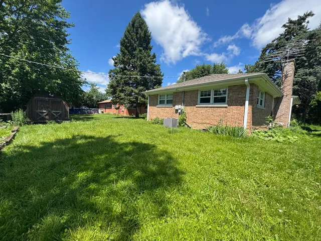 a front view of a house with a yard and trees