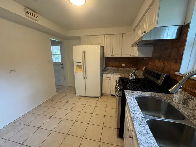 a kitchen with a sink a refrigerator and cabinets