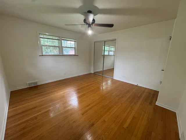 a view of an empty room with a chandelier fan