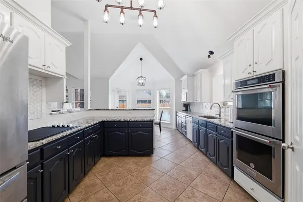 a large kitchen with cabinets stove top oven and stainless steel appliances