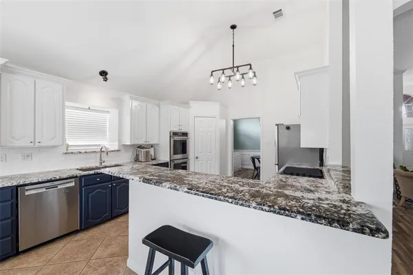 a kitchen with stainless steel appliances granite countertop a sink a stove and a refrigerator