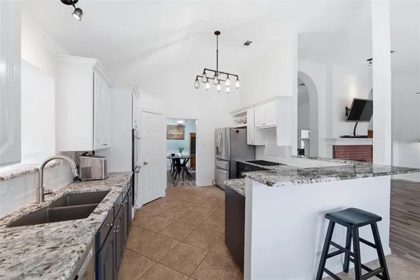 a kitchen with stainless steel appliances granite countertop a sink stove and cabinets