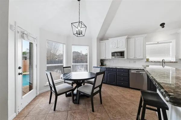 a kitchen with a dining table chairs and refrigerator