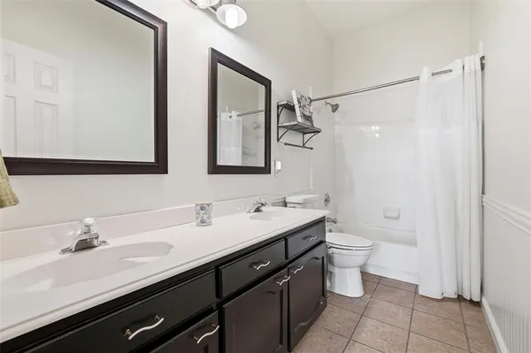 a bathroom with a double vanity sink a toilet and a mirror