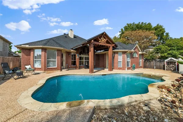 a view of a house with swimming pool and sitting area