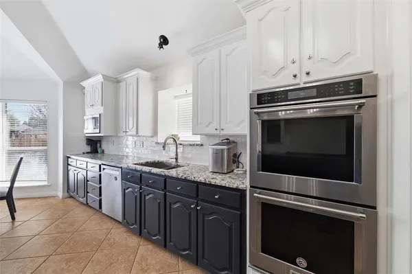 a kitchen with stainless steel appliances granite countertop a stove microwave and sink