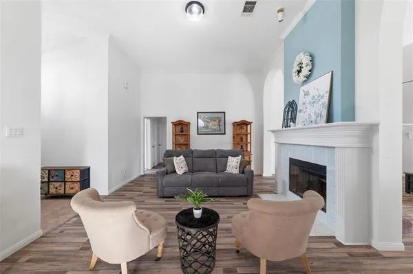 a living room with furniture a fireplace and wooden floor