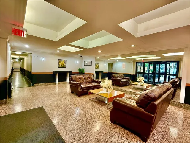 a living room with furniture kitchen view and a large window