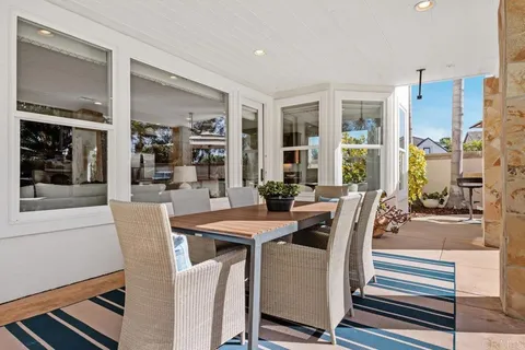 a view of a white house with a big yard and potted plants