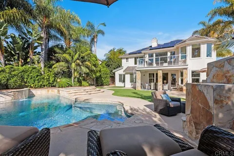 an aerial view of residential houses with outdoor space and trees