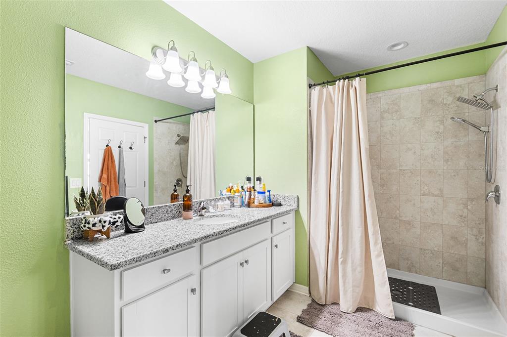 12960 Conquistador Loop Spring Hill, FL 34610 - Photo 16 of 26 a bathroom with a double vanity sink mirror and shower