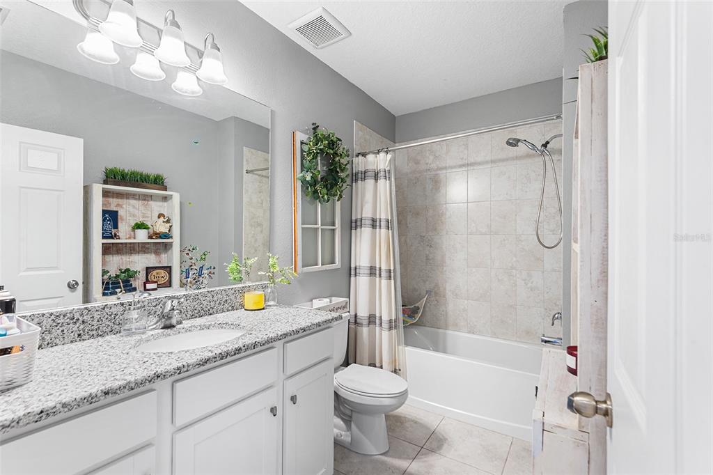 12960 Conquistador Loop Spring Hill, FL 34610 - Photo 21 of 26 a bathroom with a granite countertop sink toilet mirror and bathtub