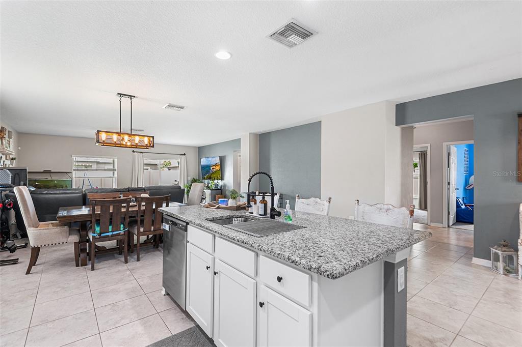 12960 Conquistador Loop Spring Hill, FL 34610 - Photo 7 of 26 a kitchen with sink cabinets and dining table