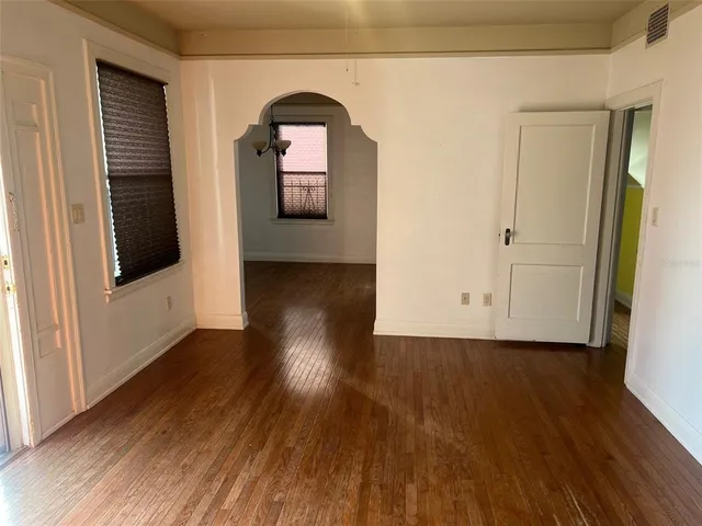 an empty room with wooden floor and a window