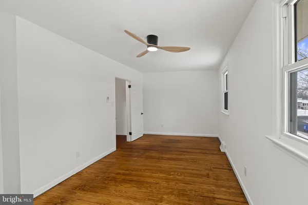 a view of a big room with wooden floor and windows