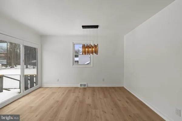 an empty room with wooden floor and glass door
