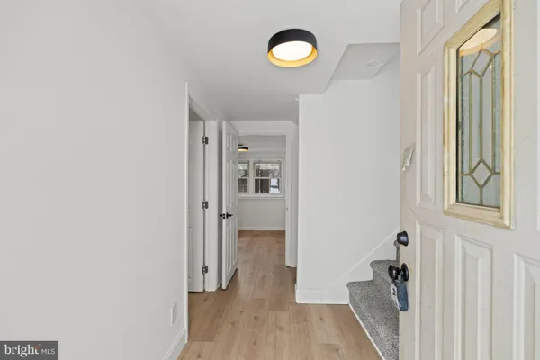 a view of a hallway with wooden floor and closet