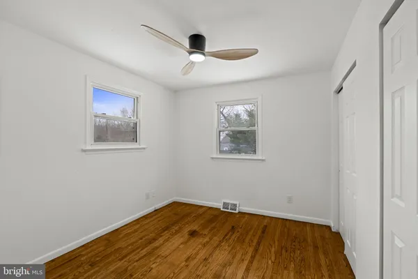 a view of empty room with wooden floor
