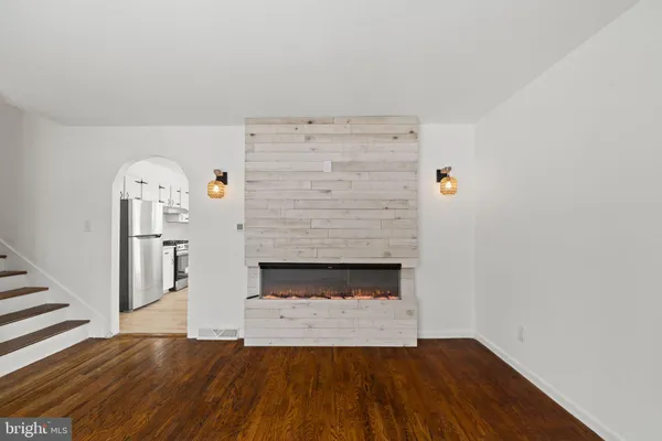 a view of empty room with fireplace and wooden floor