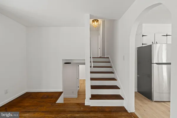 a view of a livingroom with wooden floor and stairs