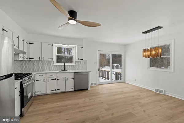 a large kitchen with granite countertop a stove top oven a sink a counter space and cabinets