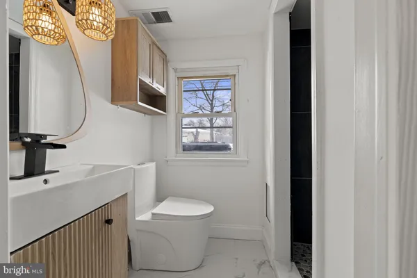 a bathroom with a toilet a sink and a mirror