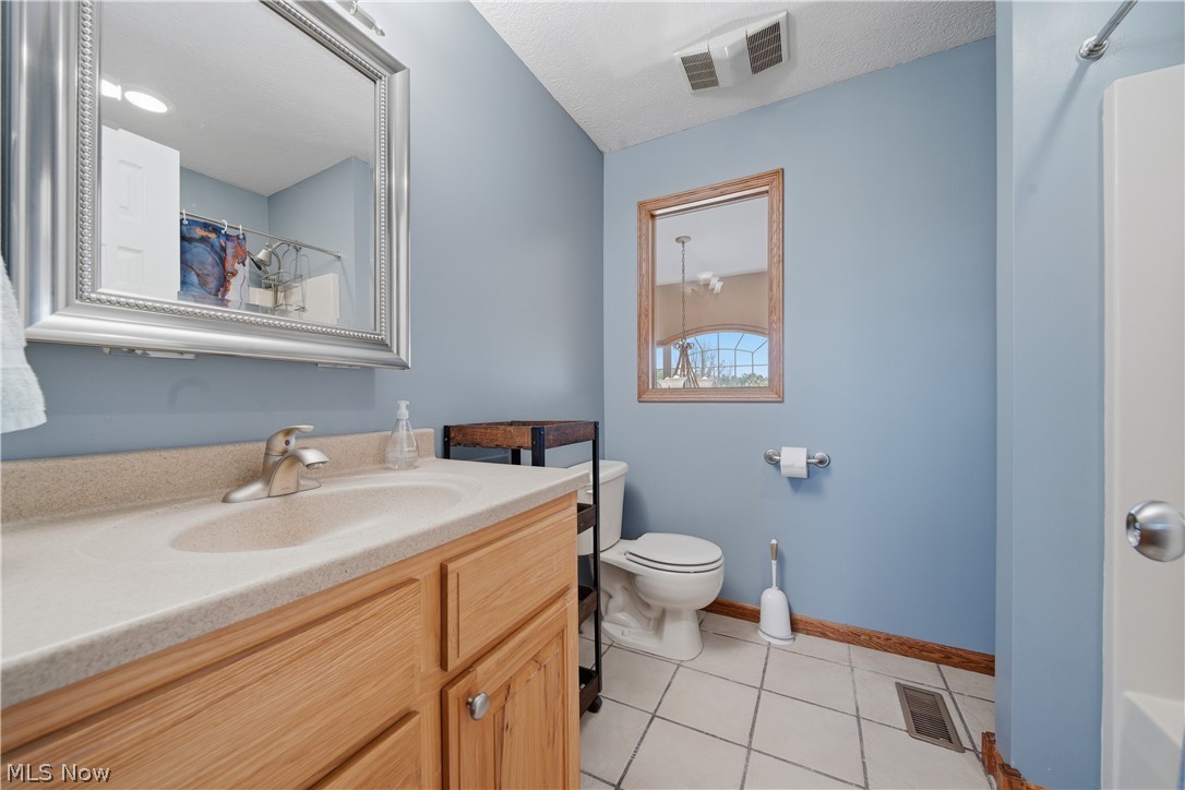 12159 Lawndell Road Southwest Beach City, OH 44608 - Photo 25 of 49 Bathroom featuring a light blue wall color, wood-finish vanity with a built-in sink, framed mirror, tiled flooring, and a window with wood trim