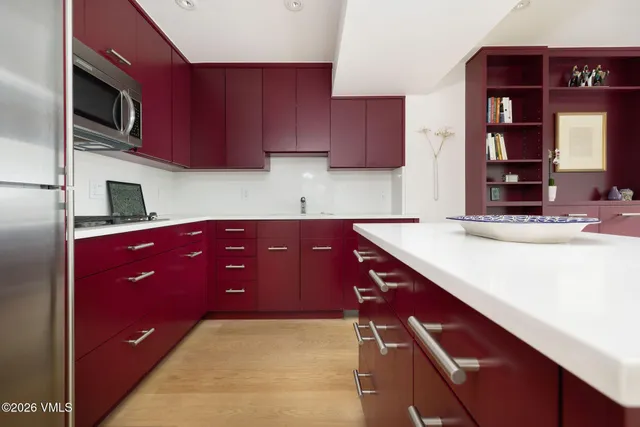 a kitchen with stainless steel appliances kitchen island granite countertop a refrigerator and a stove top oven