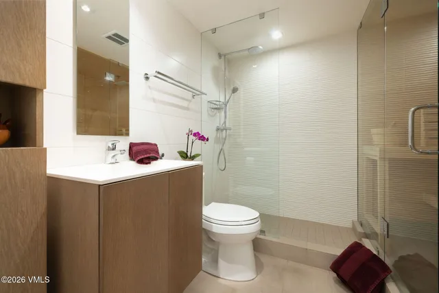 a bathroom with a sink vanity mirror and toilet
