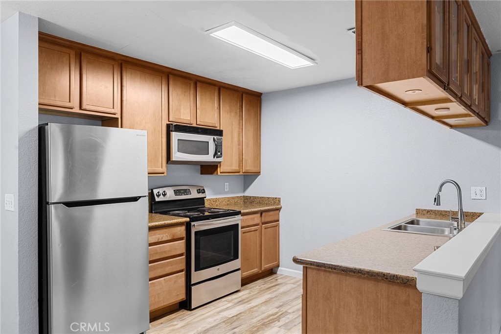 1114 Nord Avenue, Unit 11 Chico, CA 95926 - Photo 28 of 47 a kitchen with granite countertop stainless steel appliances a refrigerator stove and microwave