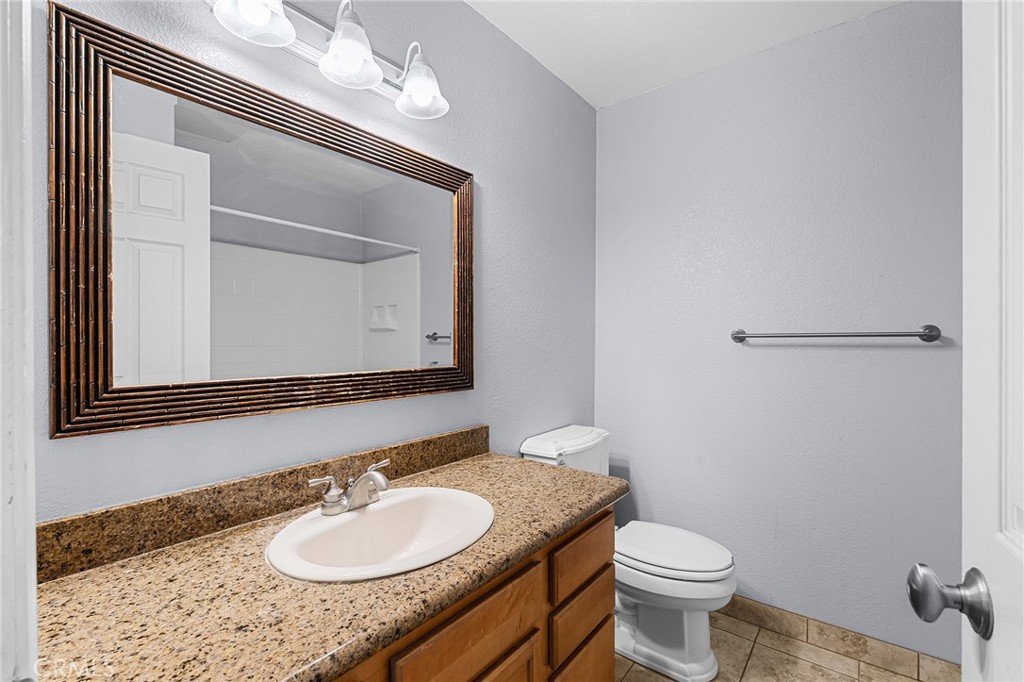 1114 Nord Avenue, Unit 11 Chico, CA 95926 - Photo 34 of 47 a bathroom with a granite countertop sink vanity mirror and toilet