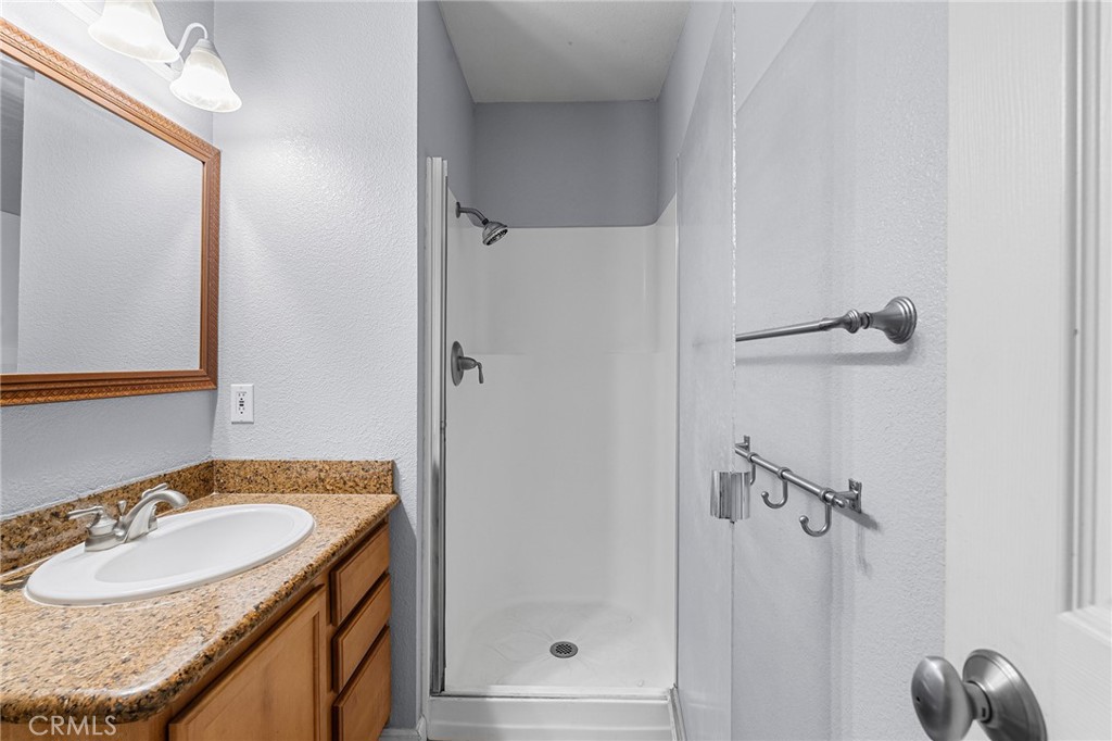 1114 Nord Avenue, Unit 11 Chico, CA 95926 - Photo 41 of 47 a bathroom with a granite countertop sink a mirror and shower