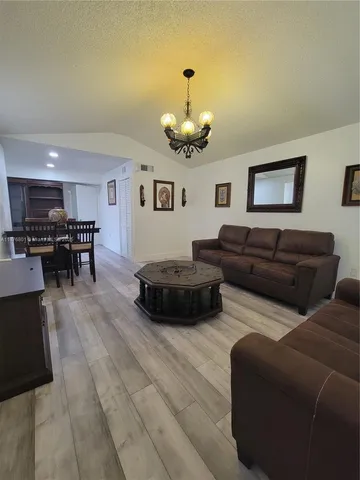 a living room with furniture kitchen view and a dining table