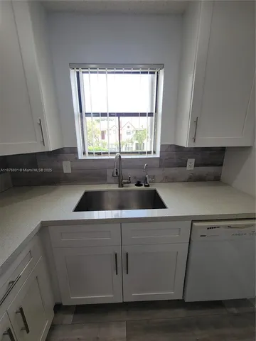 a kitchen with a sink a window and cabinets