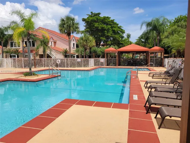 a view of a swimming pool with a table and chairs under an umbrella