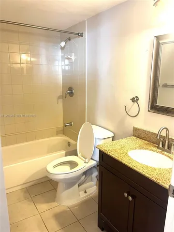 a bathroom with a granite countertop toilet sink and mirror