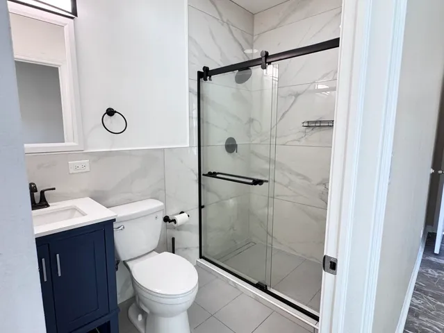 a bathroom with a toilet sink vanity and shower
