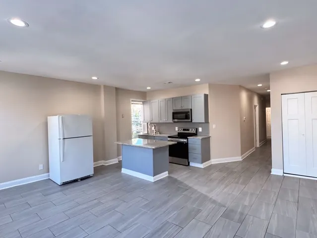 a kitchen with a refrigerator and a stove top oven