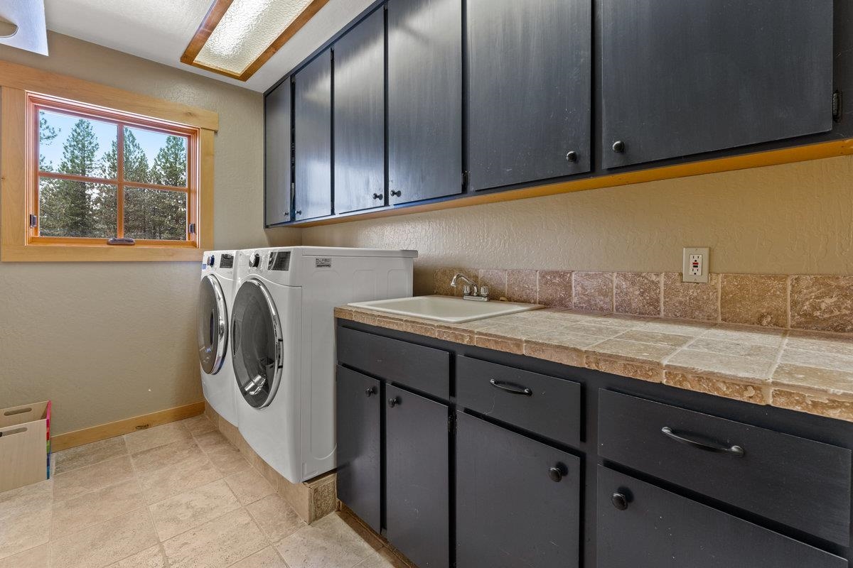 424 Chipmunk Street Kings Beach, CA 96143 - Photo 17 of 21 a utility room with granite countertop a sink a washer and dryer next to a window