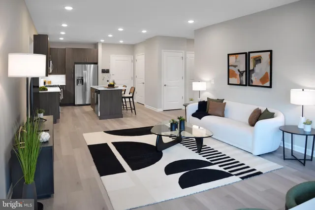 a kitchen with stainless steel appliances granite countertop a refrigerator a stove a sink and a dining table with wooden cabinet