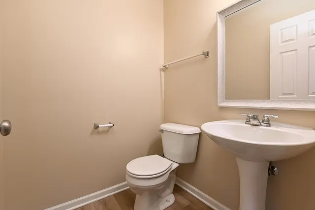 a bathroom with a sink a toilet and mirror