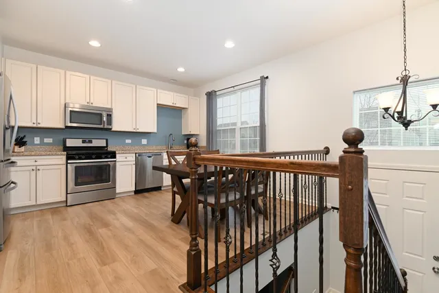 a kitchen with kitchen island a stove a sink a dining table and chairs