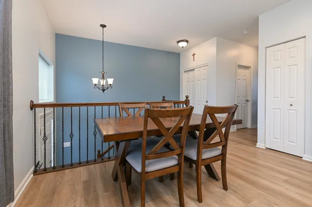 a view of a dining room and livingroom with furniture wooden floor a chandelier