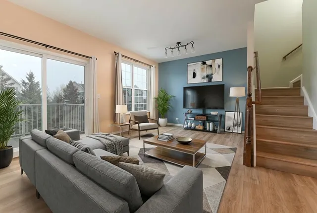 a living room with furniture a flat screen tv and a floor to ceiling window